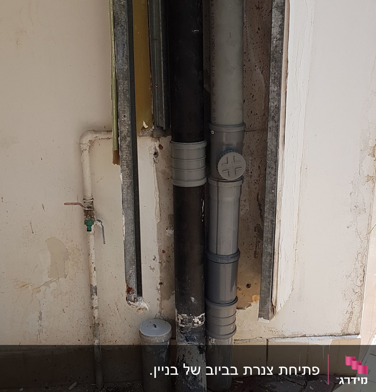 צינורות ביוב וקיר עם ברז מים